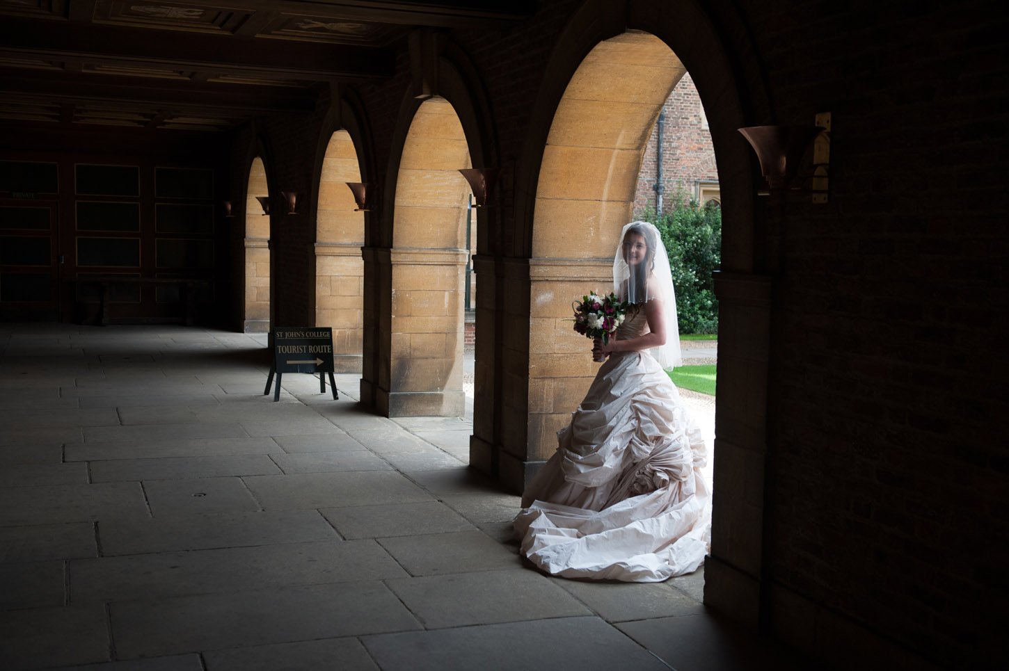 Bride portrait under covered archway in Cambridge with soft natural light