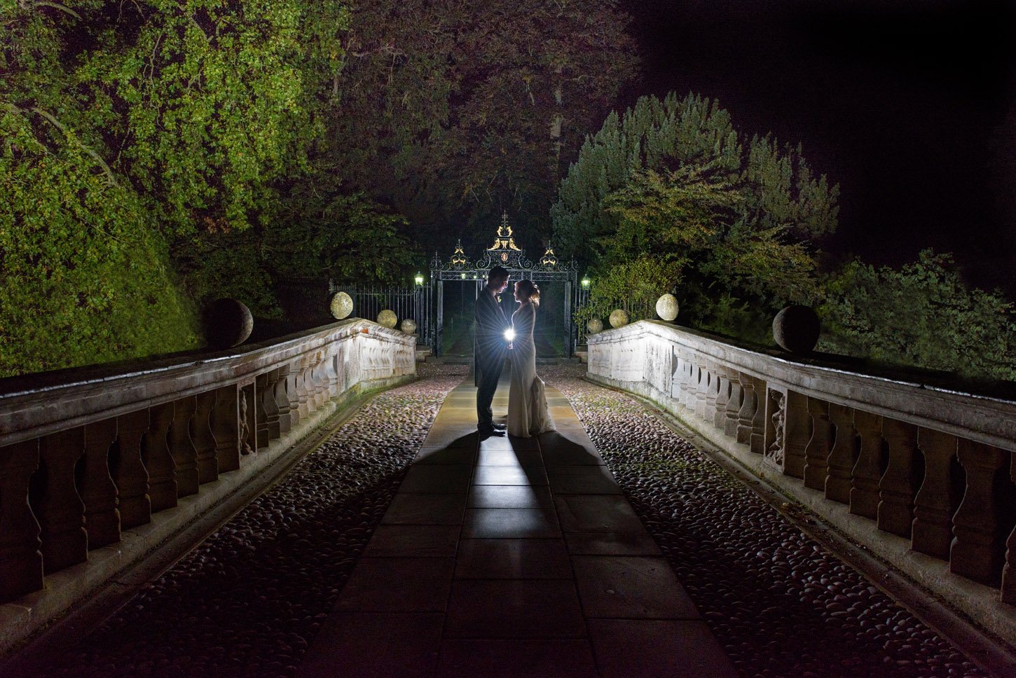 Night-time wedding portrait with dramatic backlight