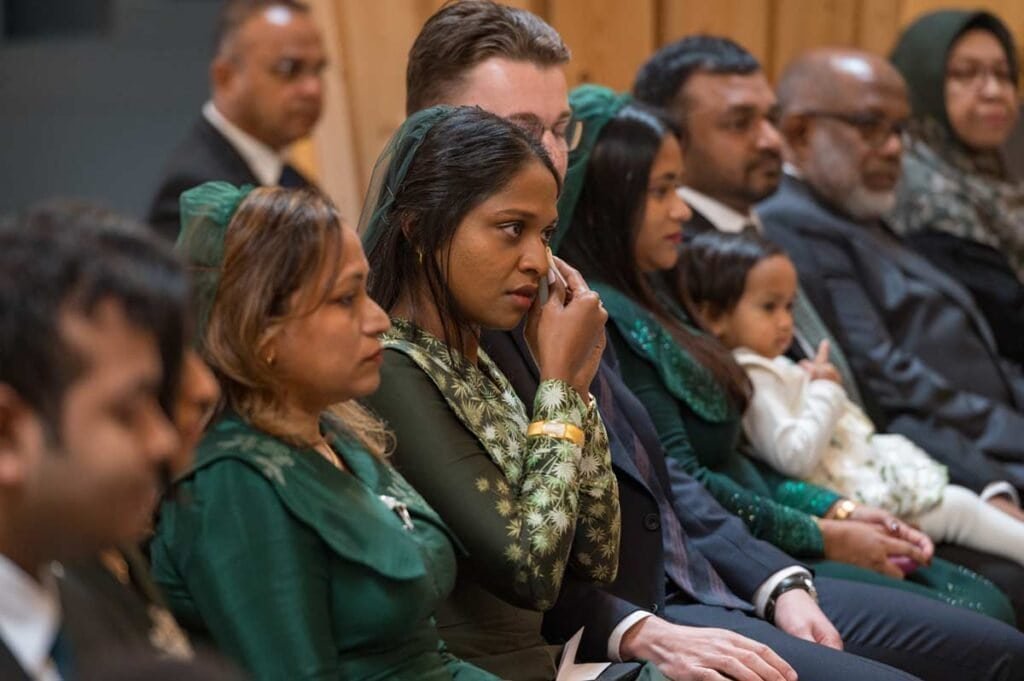 Audience of diverse individuals listening attentively at a cambridge event.